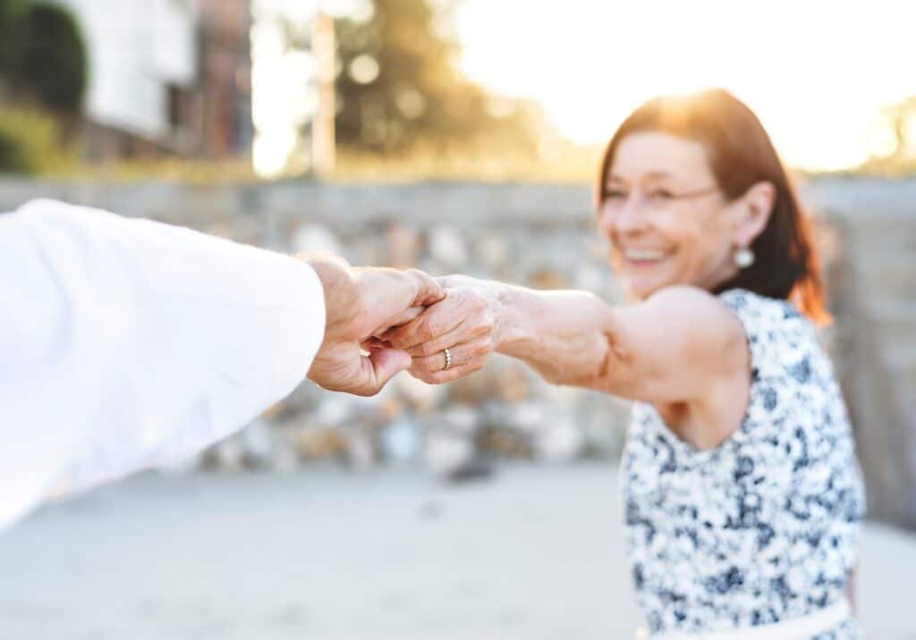 Happy couple holding hands outside